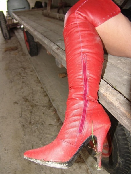 Goth meisje Lady Angelina poseert in latex kleding in een boerderij opslaggebouw