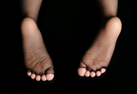 Una mujer ocasional muestra sus dedos de los pies cuidados en medias sin dedos