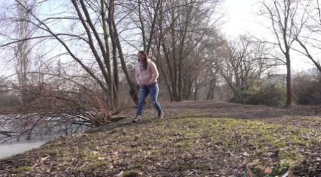 White girl Nicolette Noir takes a pee near the water while out for a walk