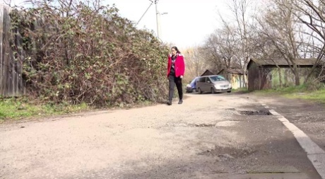 Caucasian female Ali Bordeaux squats for a piss against a wooden fence