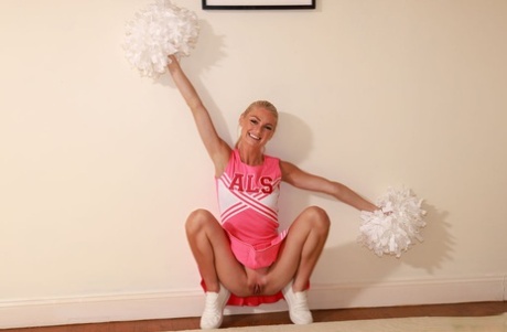 Blond cheerleaderka Payton Avery rozkłada swoje długie nogi po rozebraniu się do naga