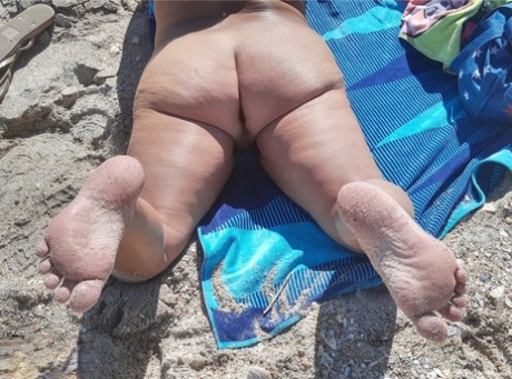 L'anziana amatoriale Debbie Delicious prende il sole in ombra su una spiaggia nudista