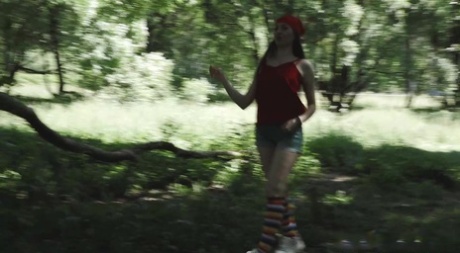 Young blonde Larisa takes a pee behind a tree in multi-coloured knee socks