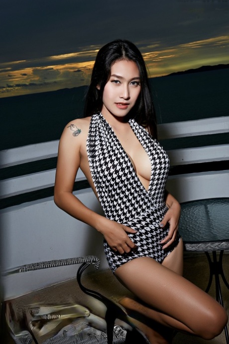 Den vackra asiatiska flickan Linlin är helt naken på en balkong vid havet