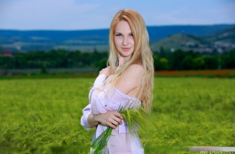 Young strawberry blonde models naked on a blanket in a field of barley