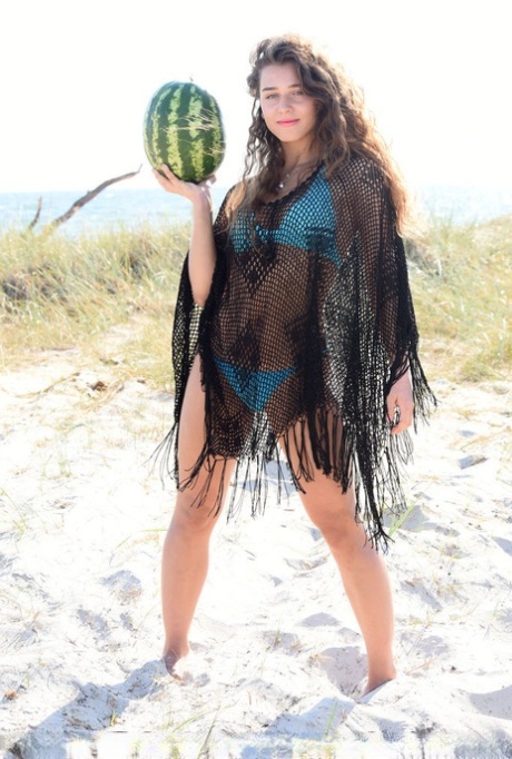 Young solo girl Kailyn cracks open a watermelon while getting naked on a beach