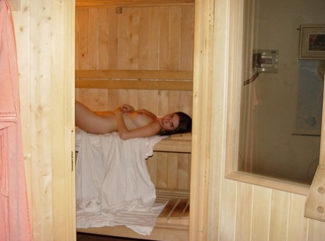 A amadora nua Vivian insere um brinquedo sexual enquanto relaxa numa sauna