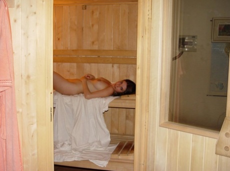 Naked amateur Vivian inserts a sex toy while relaxing in a sauna