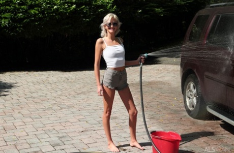 Den platinablonde tenåringen Tallie Lorain kler seg helt naken mens hun vasker en bil.
