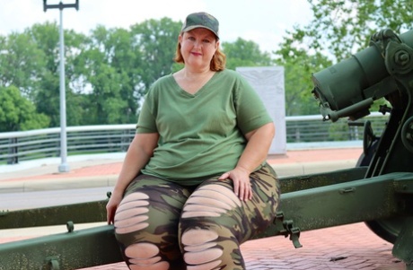 Obese amateur Goddess Pear models for a SFW shoot on an artillery gun in camo