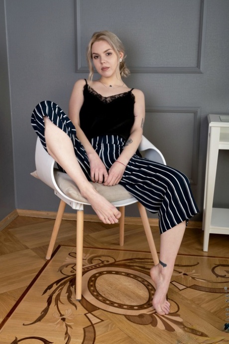 La joven rubia Hannah Blu pone su hermoso cuerpo libre de ropa en una silla