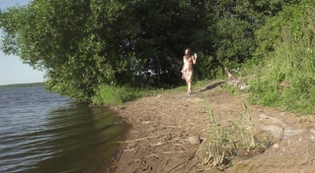 Lange brunette Sasha S hurkt voor een dringende plas aan de oever van een meer