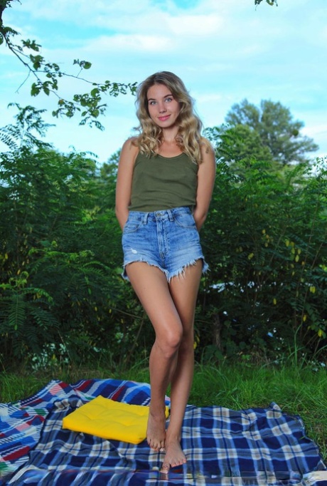 Young blonde Lola Krit showcases her bold pussy on a blanket on a lawn