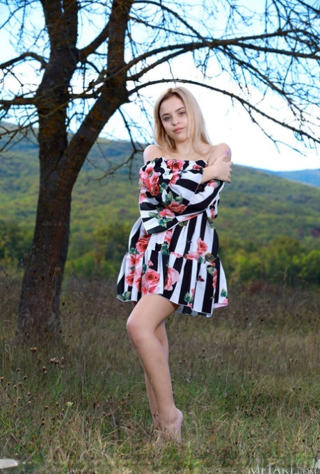 Mooie blonde tiener Monika Jelolt ligt helemaal naakt op een deken in een veld