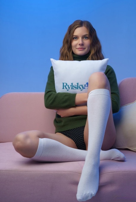 Beautiful teen Lana Broks gets naked on a sofa in white knee socks