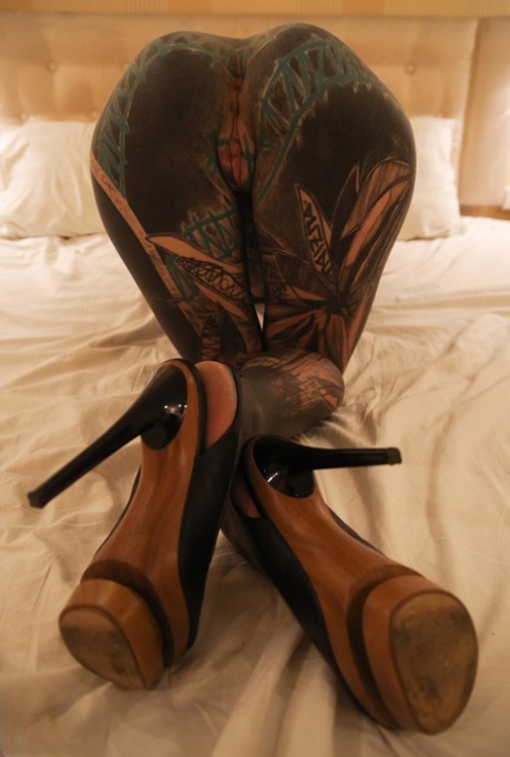 En stærkt tatoveret pige knuger sin fisse efter at have onaneret med et sexlegetøj