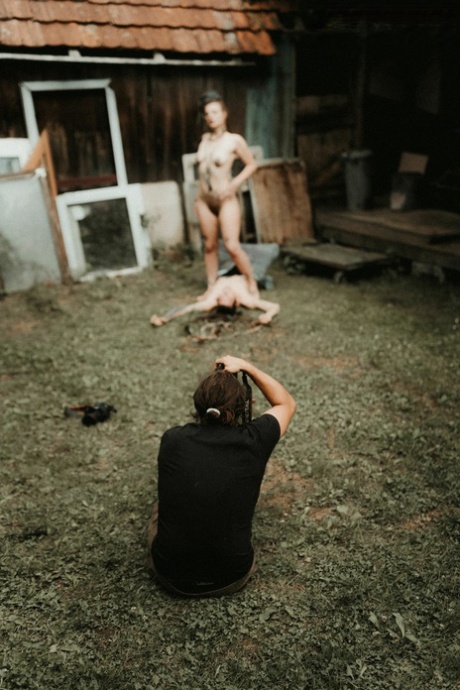 满身纹身的女孩在一栋房子后面的台阶外向一名裸体男子撒尿