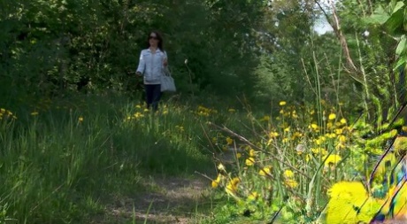 Den kaukasiske jenta Kristina trekker ned buksene for å pisse på en landevei.