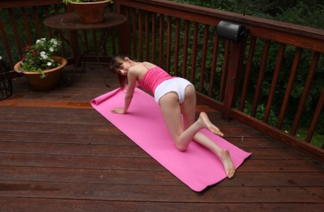 Flexibel jong meisje Lana Smalls gaat naakt terwijl ze yoga doet op een terras