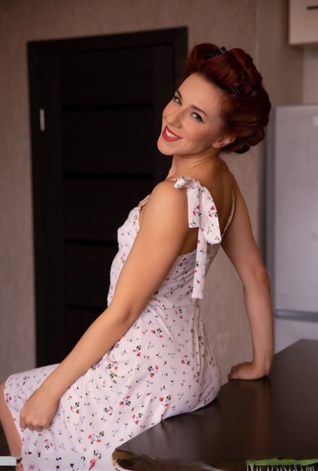 Pretty redhead Oxi Bendini wears her hair pinned up while getting bare naked