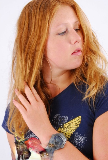 Natural redhead Judy displays her grey G-Shock watch in a T-shirt and jeans