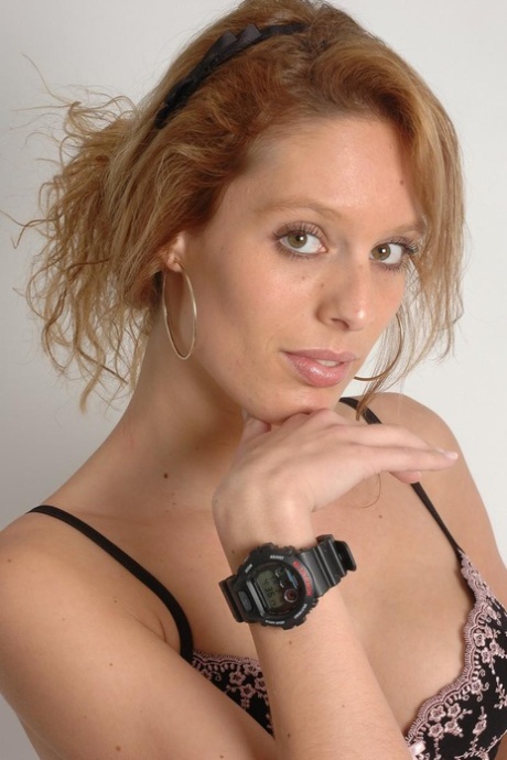 Rudowłosa amatorka Fleur ma na sobie kajdanki, zegarek i ładne dodatki.