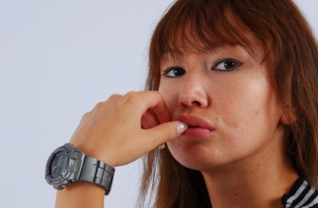 Asian redhead Evita models a grey G-Shock watch while fully clothed