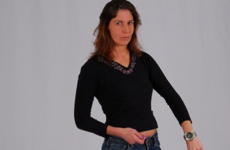 Den kaukasiske model Felicia kigger på sit store metalur, mens hun er påklædt.