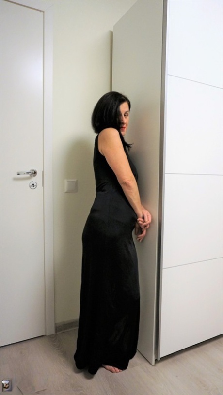Diana Ananta, donna dai capelli scuri, alza il suo abito lungo per mostrare la sua fica rifilata