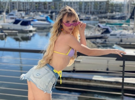 Blonde tiener met lang haar Lilly Bell modelleert een bikini voor een BJ en een gezichtsbehandeling