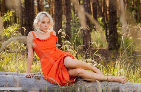 Lily Shawn, une adolescente blonde, se met totalement nue sur une couverture dans une forêt.