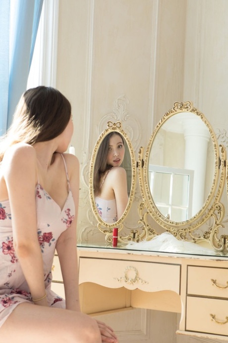 La jeune brune Suok dénude son corps pour une séance de photos de nu sur son lit.