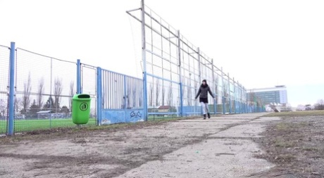 White girl Mistica takes a piss next to a fence in a public location