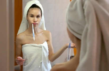 A adolescente magra Leona Mia tira as toalhas de banho antes de posar nua