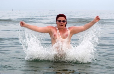 Reife Rothaarige Mollie Foxxx benetzt ihren tätowierten Körper im Meer