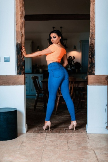 La sexy morena Blossom May se desnuda hasta los tacones en un arco