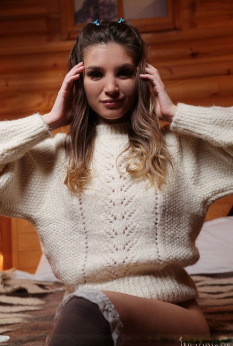 Gorgeous teen Emilia Hops doffs a big sweater to model nude in OTK hosiery