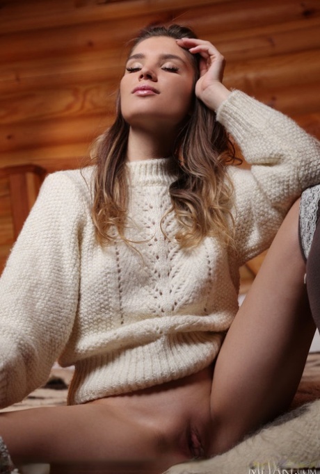 Gorgeous teen Emilia Hops doffs a big sweater to model nude in OTK hosiery