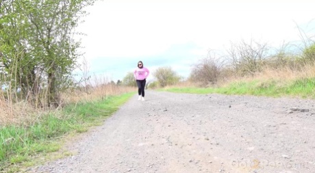 Solo girl Barbara Bieber pulls down her leggings to pee on a country road