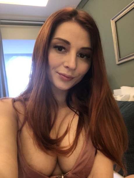 Sexy brunette tar selfies i speilet mens hun dusjer naken med rumpa i været