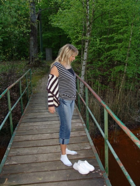 Die blonde Sweet Susi mittleren Alters wird bei einem Spaziergang durch einen Naturpark splitternackt