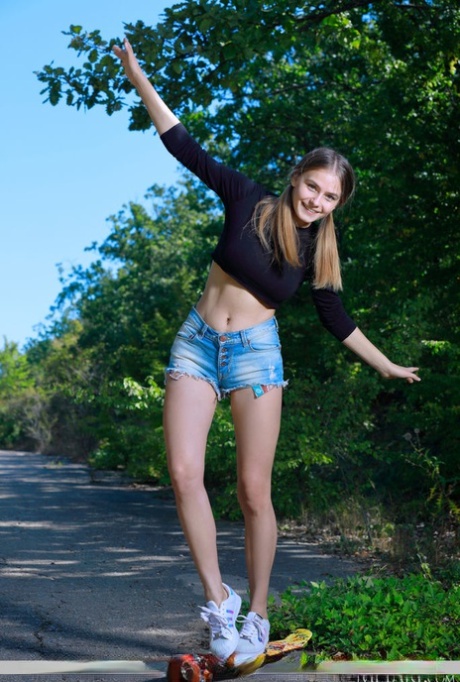 Teenage-solopigen Dakota Pink blotter sin himmelske krop på en asfalteret vej