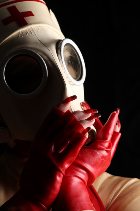 Caucasian fetish model Avengelique sports a gas mask in a latex nurse outfit