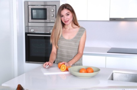 A adorável adolescente Kaleesy fica completamente nua num banco de cozinha