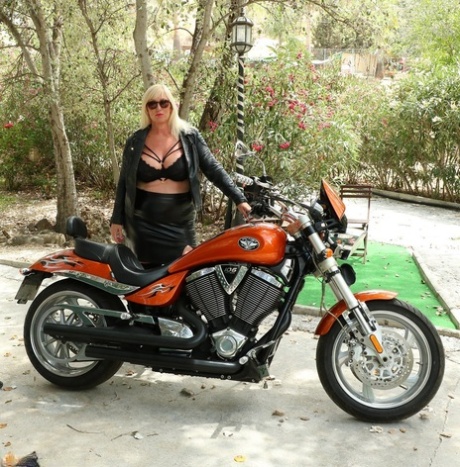 Den modne blondinen Melody viser frem de store brystene sine på en motorsykkel.