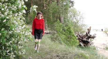 Caucasian girl squats behind a bush for a badly needed pee