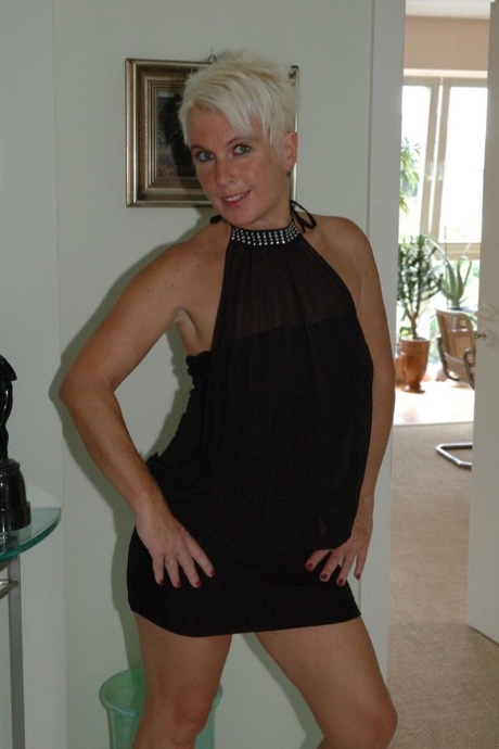 Mature platinum blonde Claudia works her natural tits free of a black dress