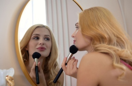 Den unge, blonde Scarlett Queen lægger makeup, før hun er helt nøgen