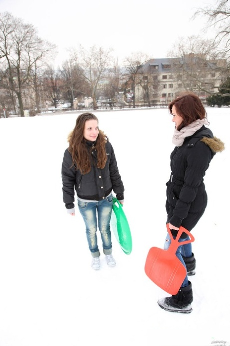 Jonge lesbiennes hebben seks op een bed nadat ze van een besneeuwde heuvel zijn gegleden