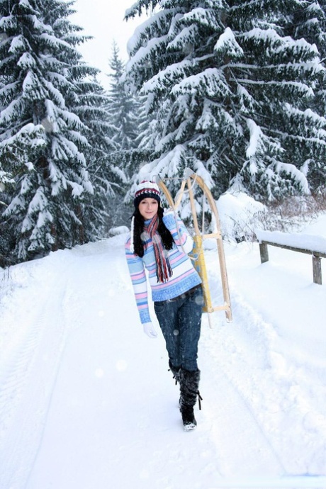 年轻的女孩在冬日里用玩具在雪橇上自慰